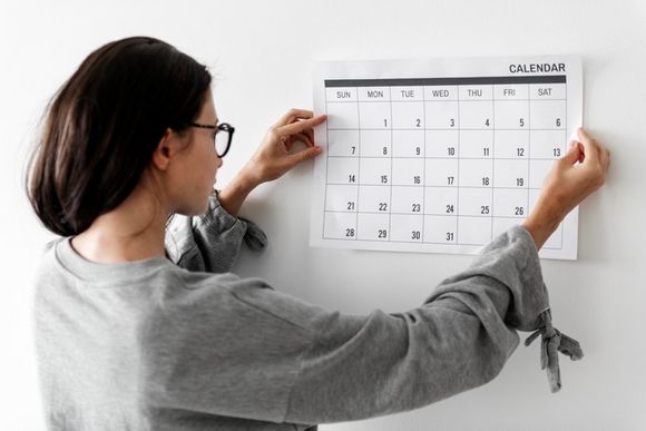 Frau hängt Kalender an die Wand