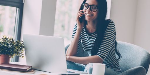 Frau am Telefon während sie ihr Anschreiben bearbeitet