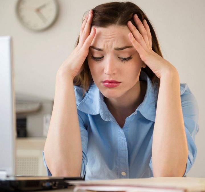 Neuer Job – falsche Entscheidung: Frau sitzt unglücklich vor dem Computer.