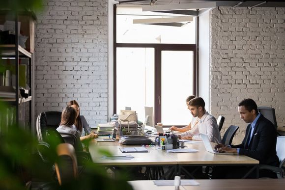 Mitarbeiter nutzen Vorteile von Desk Sharing im Büro