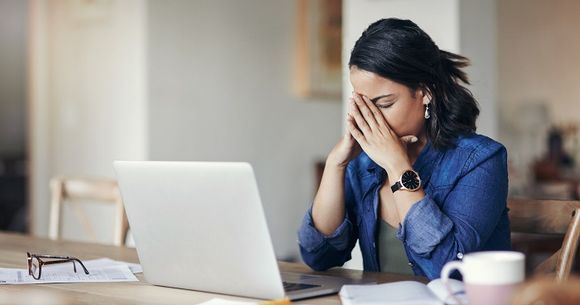 Frau denkend am Laptop