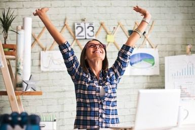 Frau freut sich am Arbeitsplatz - über ihren guten Job
