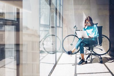 Frau am Laptop auf Bürostuhl