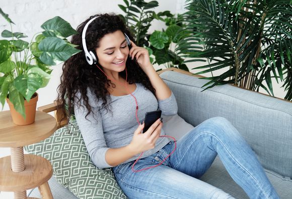 junge Frau hört sich einen Podcast an