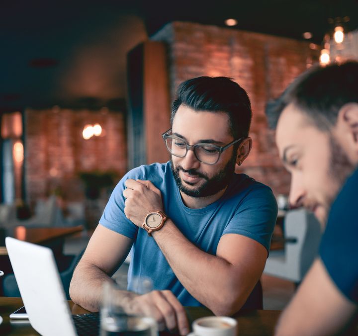 zwei Männer sitzen zusammen und arbeiten