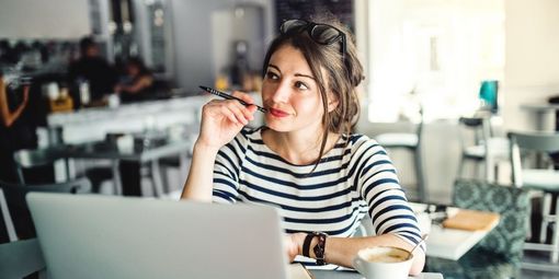 Frau schreibt englische Bewerbung auf Laptop