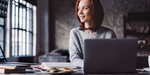 Lächelnde Frau arbeitet am Laptop