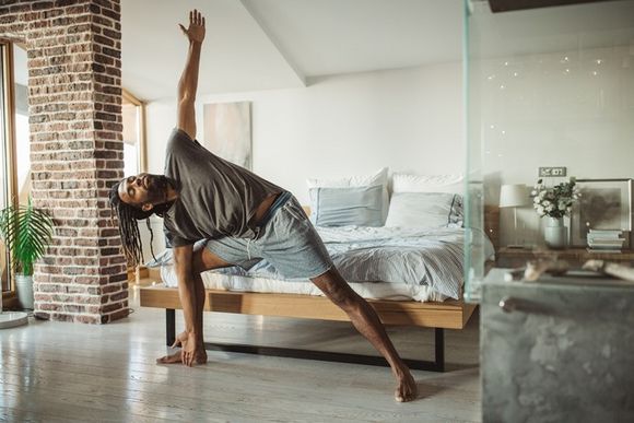 Mann macht Yoga bei Morgenroutine 